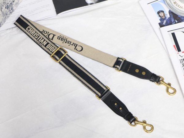 DIOR Christian Dior Shoulder Strap. Original Quality Strap including gift box, care book, dust bag, authenticity card. The 'Christian Dior' signature is featured at the center of the slender shape, framed by black calfskin on either side. Two antique gold-finish metal snap hooks attach the strap to the bag of choice. The strap may be worn over the shoulder or crossbody for a highly personalized style.