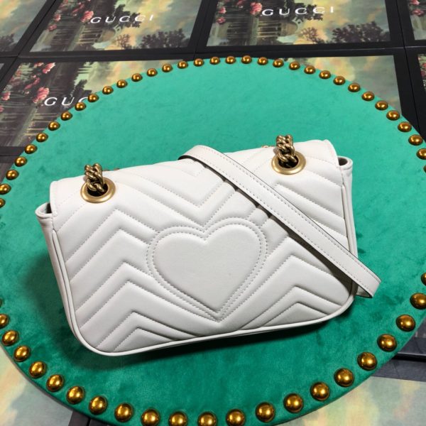 GUCCI GG Marmont Matelassé Mini Bag. High-end quality bag including gift box, literature, dust bag, authenticity card. The small GG Marmont chain shoulder bag has a softly structured shape and an oversized flap closure with Double G hardware. The sliding chain strap can be worn in multiple ways, changing between a shoulder and a top handle bag. Made in matelassé chevron leather with a heart on the back.