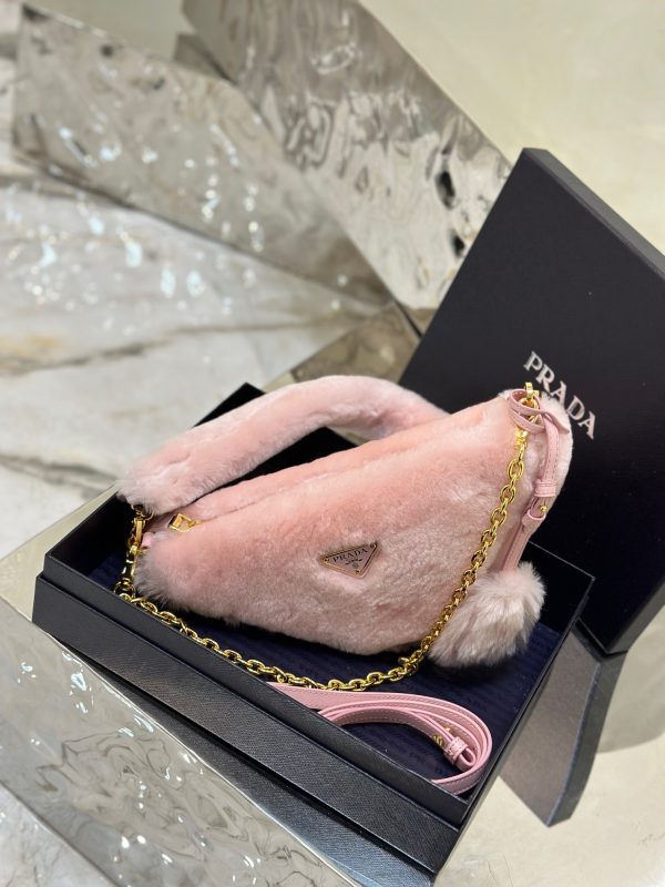 PRADA Shearling Mini Bag. Original Quality Bag including gift box, care book, dust bag, authenticity card. The softness and fuzziness of shearling accentuate the modern, wintry allure of this mini-bag characterized by its harmonious and delicate shape. The bag accented with a chain handle is decorated with the enameled metal triangle logo.