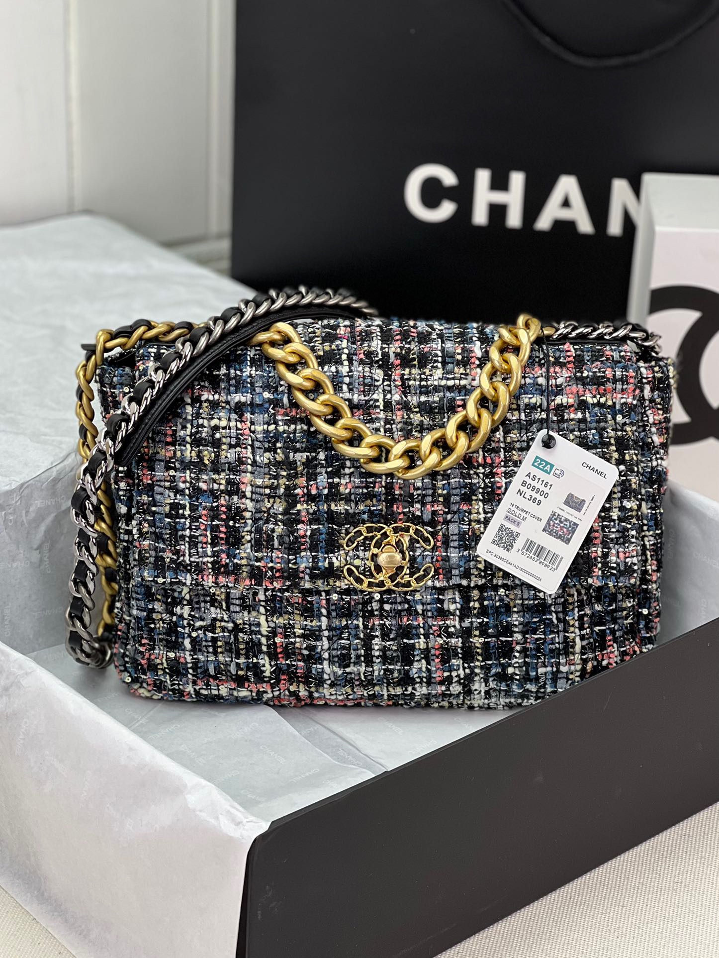 CHANEL 19 Tweed Flap Bag. Original Quality Bag including gift box, care book, dust bag, authenticity card. This Chanel 19 Flap Bag ticks all boxes and is quite possibly the most sought after bag in the world at this moment. Constructed from beautifully constructed Tweed Fibres and paired with the iconic Chanel 19 two-tone hardware, both Gold and Ruthenium. The refined bag features an aged gold chain detail CC turn-lock on the flap, a magnetic snap pocket at the rear and a leather threaded gradient gold to ruthenium chain-link strap with a leather shoulder pad. The front flap opens to a black fabric interior with a zipper pocket. This versatile bag with soft leather is an essential bag for any Chanel aficionado.