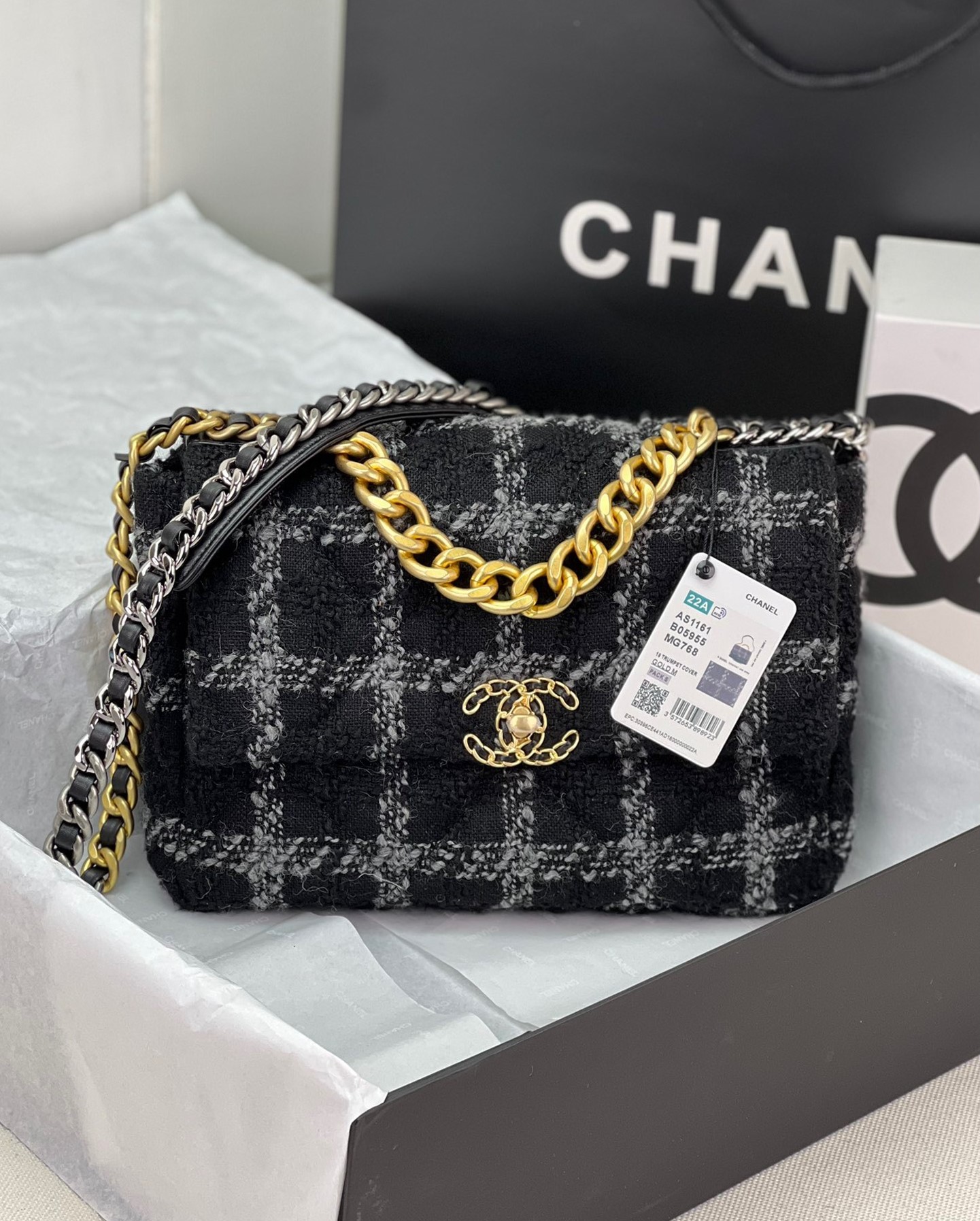 CHANEL 19 Tweed Flap Bag. Original Quality Bag including gift box, care book, dust bag, authenticity card. This Chanel 19 Flap Bag ticks all boxes and is quite possibly the most sought after bag in the world at this moment. Constructed from beautifully constructed Tweed Fibres and paired with the iconic Chanel 19 two-tone hardware, both Gold and Ruthenium. The refined bag features an aged gold chain detail CC turn-lock on the flap, a magnetic snap pocket at the rear and a leather threaded gradient gold to ruthenium chain-link strap with a leather shoulder pad. The front flap opens to a black fabric interior with a zipper pocket. This versatile bag with soft leather is an essential bag for any Chanel aficionado.