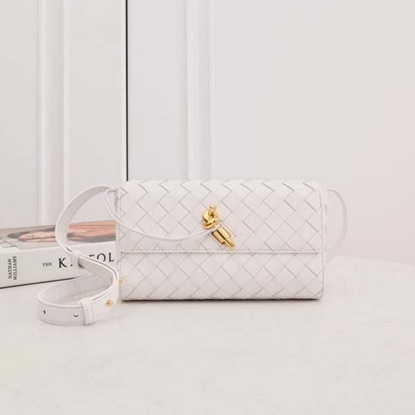 BOTTEGA VENETA Mini Andiamo: Timeless Craftsmanship, Effortless Versatility. Discover Bottega Veneta’s latest addition to the 'Andiamo' collection by Creative Director Matthieu Blazy. This exquisite bag is meticulously hand-woven from supple leather strips, showcasing the brand's iconic intrecciato technique. The design is elevated by a luxurious gilded 'Knot' detail at the front, adding a touch of elegance. Inside, you’ll find a compact interior with a zipped pocket, perfect for organizing your essentials. For ultimate versatility, tuck in the shoulder strap and transform this piece into a sophisticated clutch. With the Andiamo bag, style meets function in timeless Bottega Veneta fashion.