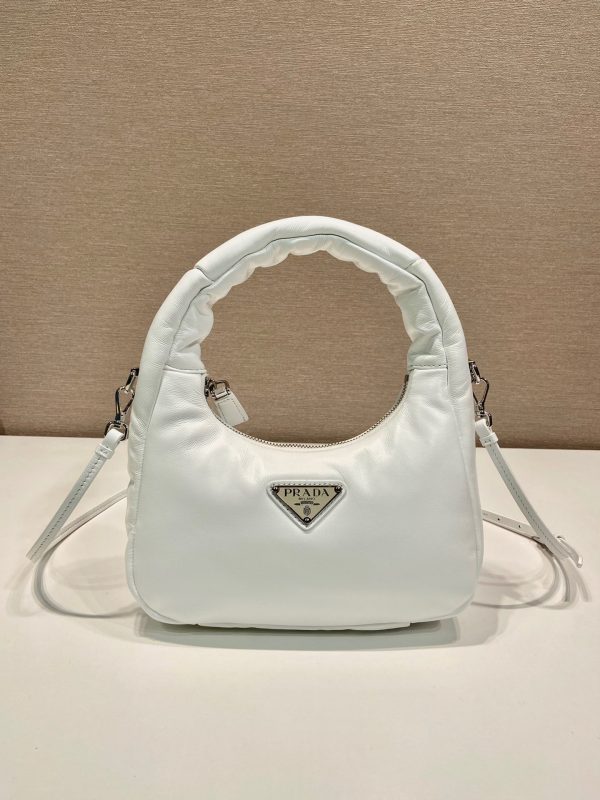 PRADA Soft Padded Mini Bag. Original Quality Bag including gift box, care book, dust bag, authenticity card. A harmonious, bold silhouette characterizes this mini-bag made of padded leather accented with the detachable, adjustable shoulder strap. Defined by its versatile allure, the accessory has a zipper closure and is decorated with the emblematic enameled metal triangle logo.
