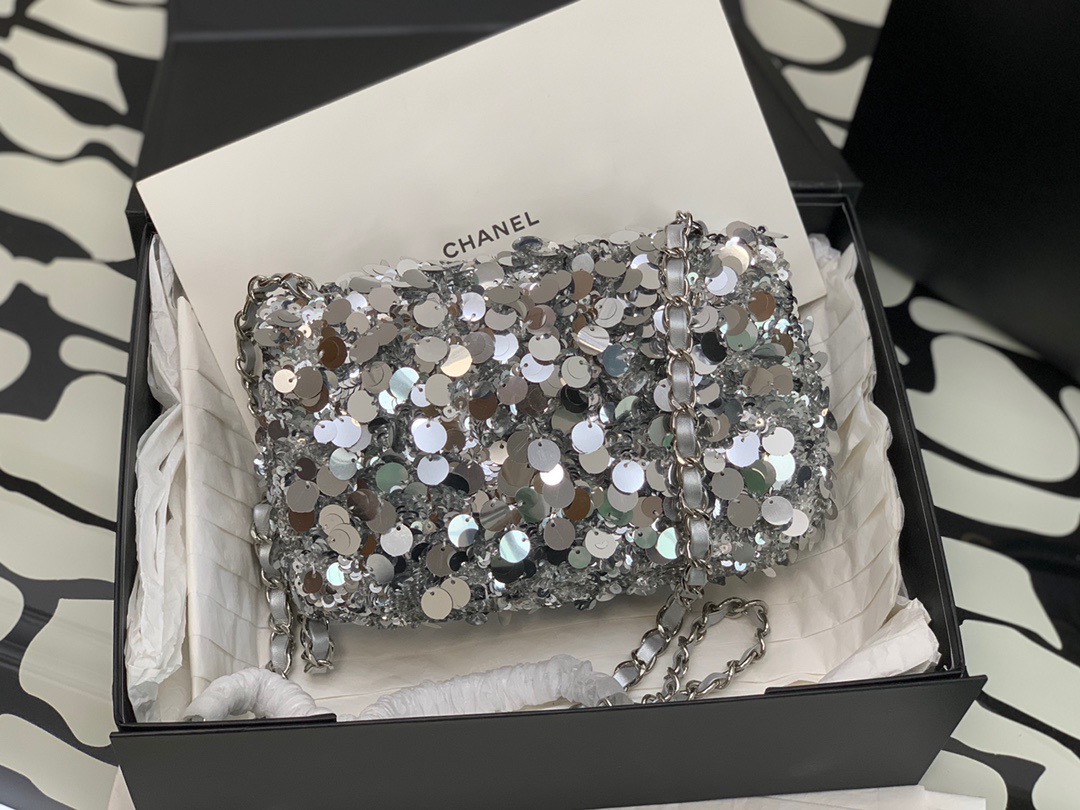 CHANEL Mini Flap Bag In Sequins. Original Quality Bag including gift box, care book, dust bag, authenticity card. This small sleek flap bag is beautifully crafted of the layering of small and large sequins that create the entire surface of the bag. The elegant handbag features polished chain link leather threaded shoulder straps and a Chanel CC turn lock. This opens to a leather interior with room for your necessities for day or evening with the timeless style.