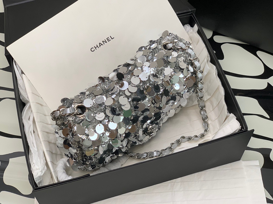 CHANEL Mini Flap Bag In Sequins. Original Quality Bag including gift box, care book, dust bag, authenticity card. This small sleek flap bag is beautifully crafted of the layering of small and large sequins that create the entire surface of the bag. The elegant handbag features polished chain link leather threaded shoulder straps and a Chanel CC turn lock. This opens to a leather interior with room for your necessities for day or evening with the timeless style.