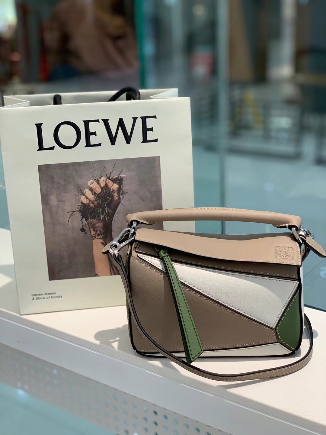 LOEWE Mini Puzzle Bag. Original Quality Bag including gift box, care book, dust bag, authenticity card. The Puzzle bag is the debut bag for LOEWE by Creative Director Jonathan Anderson. A cuboid shape and precise cutting technique create Puzzle’s distinctive geometric lines. This mini version is crafted in contrasting calfskins.