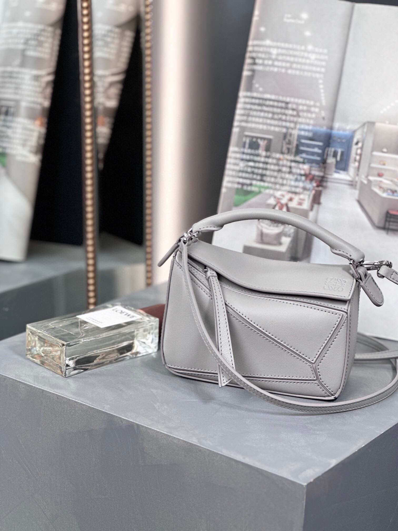 LOEWE Mini Puzzle Bag. Original Quality Bag including gift box, care book, dust bag, authenticity card. The Puzzle bag is the debut bag for LOEWE by Creative Director Jonathan Anderson. A cuboid shape and precise cutting technique create Puzzle’s distinctive geometric lines. This mini version is crafted in contrasting calfskins.