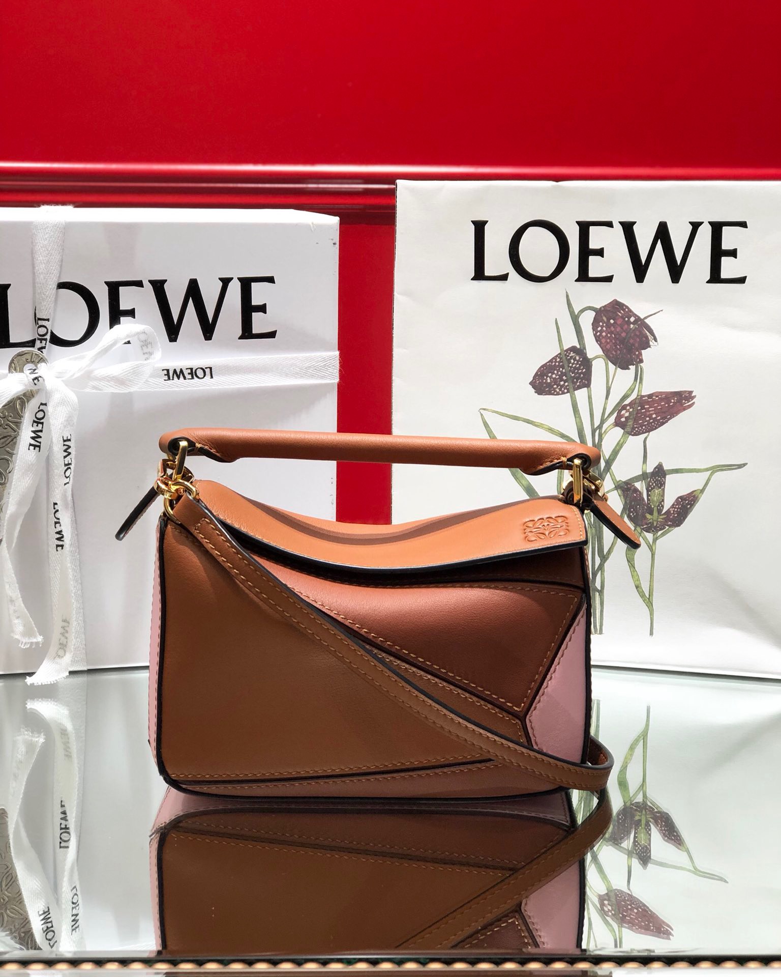 LOEWE Mini Puzzle Bag. Original Quality Bag including gift box, care book, dust bag, authenticity card. The Puzzle bag is the debut bag for LOEWE by Creative Director Jonathan Anderson. A cuboid shape and precise cutting technique create Puzzle’s distinctive geometric lines. This mini version is crafted in contrasting calfskins.