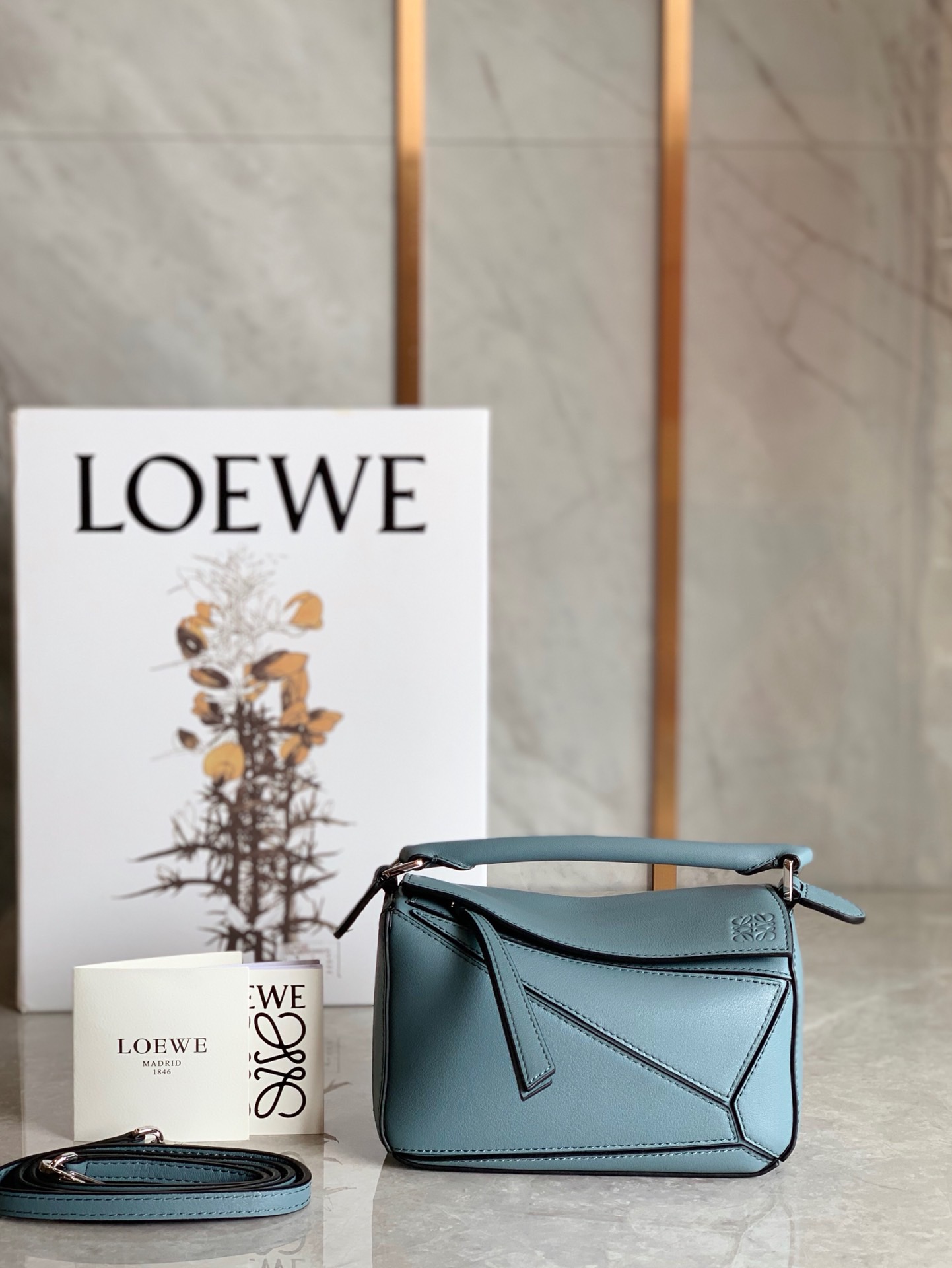 LOEWE Mini Puzzle Bag. Original Quality Bag including gift box, care book, dust bag, authenticity card. The Puzzle bag is the debut bag for LOEWE by Creative Director Jonathan Anderson. A cuboid shape and precise cutting technique create Puzzle’s distinctive geometric lines. This mini version is crafted in contrasting calfskins.