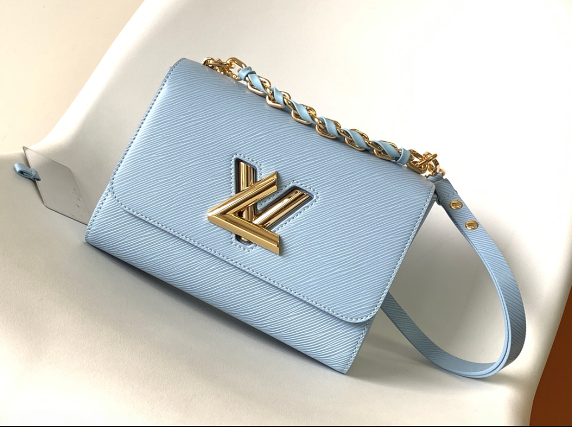LOUIS VUITTON Twist MM. Original Quality Bag including gift box, care book, dust bag, authenticity card. This glamourous Twist MM handbag is made from deep-dyed Epi grained leather and adorned with a detachable chunky gold-color chain, braided with leather. The braiding on the chain reflects Louis Vuitton’s superior leather craftsmanship. The chain is perfect for hand carry while a removable strap allows shoulder and cross-body carry.