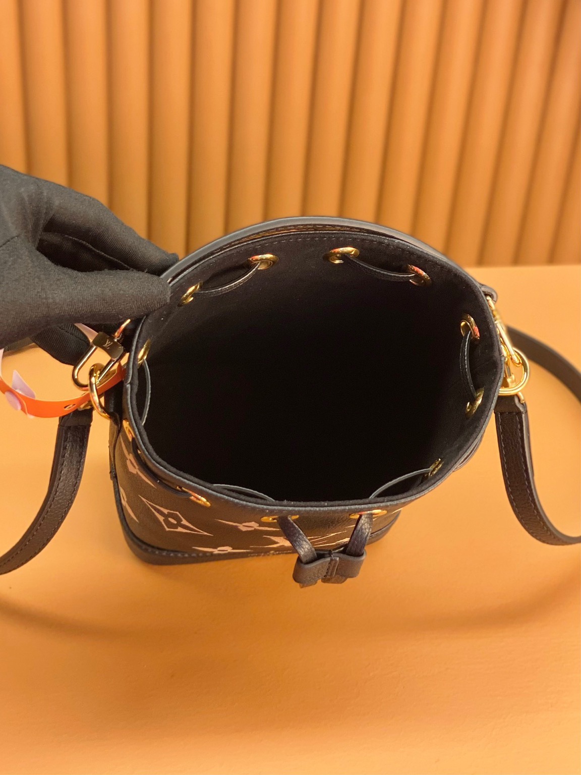 LOUIS VUITTON Nano Noé. Style meets functionality: the perfect companion for your everyday essentials. The Nano Noé in a bicolor design is made from Monogram Empreinte leather, showcasing the embossed Monogram pattern. This compact version of the iconic Noé bag adds a touch of elegance to your daily essentials. Along with a convenient drawstring closure, it also offers versatility with a detachable handle and an adjustable shoulder strap for various carrying choices.