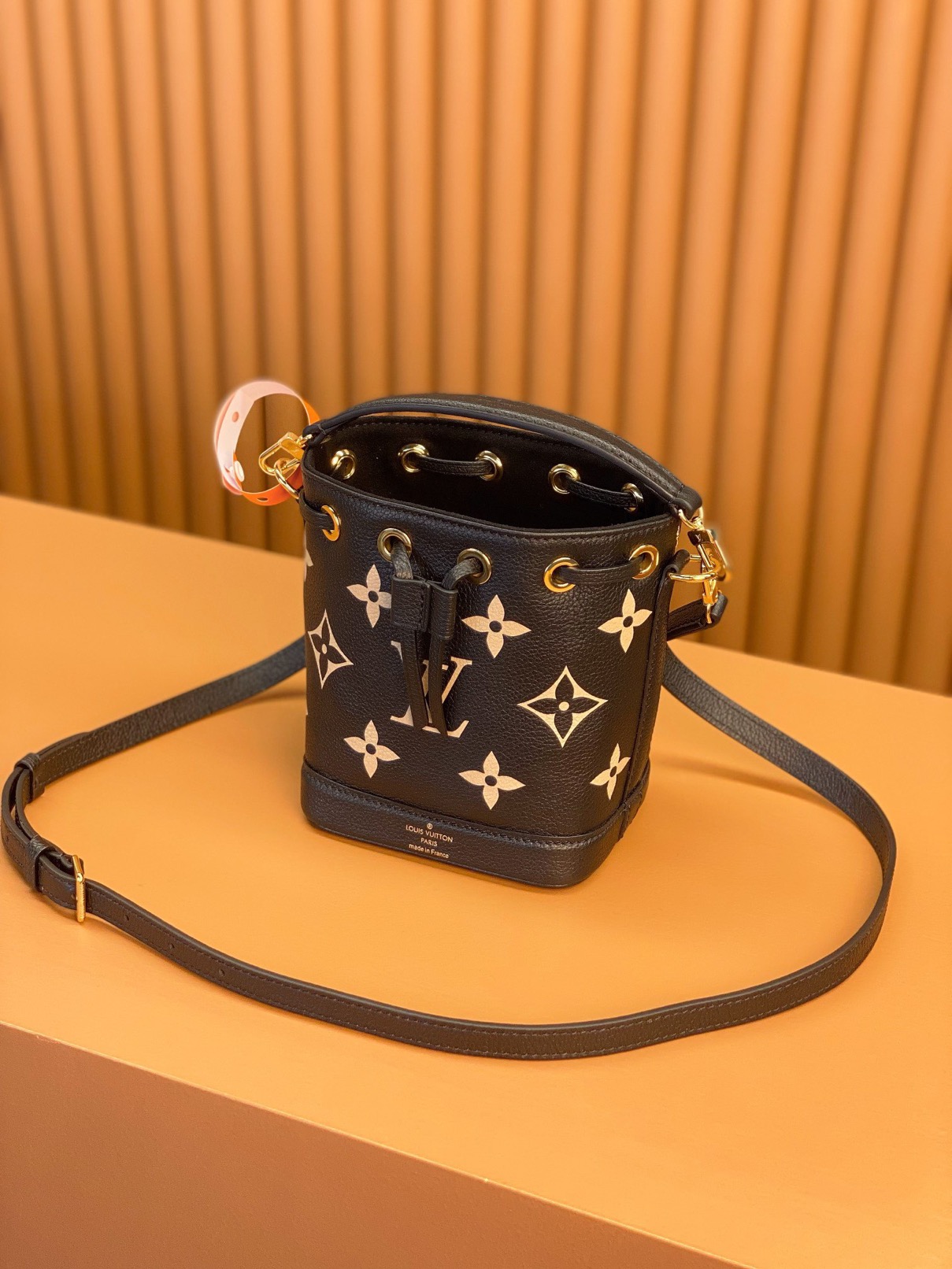 LOUIS VUITTON Nano Noé. Style meets functionality: the perfect companion for your everyday essentials. The Nano Noé in a bicolor design is made from Monogram Empreinte leather, showcasing the embossed Monogram pattern. This compact version of the iconic Noé bag adds a touch of elegance to your daily essentials. Along with a convenient drawstring closure, it also offers versatility with a detachable handle and an adjustable shoulder strap for various carrying choices.