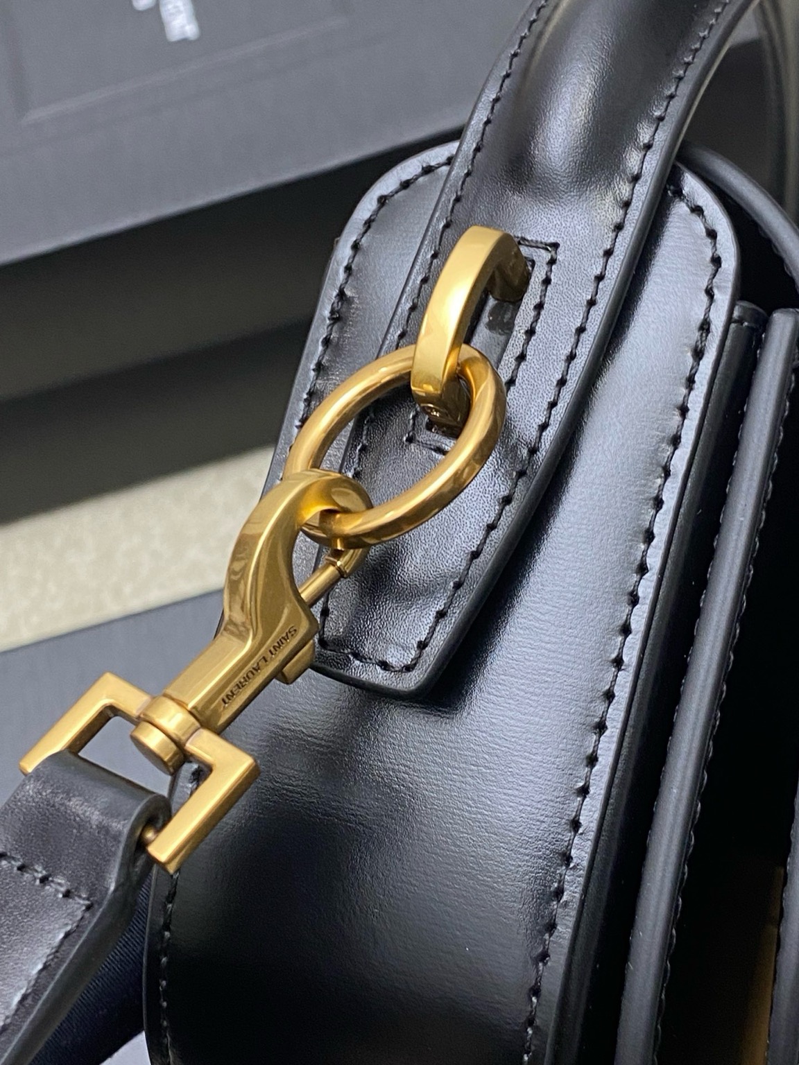 SAINT LAURENT Voltaire in Box with a Twist of Modernity: Iconic Elegance. Introducing the Half-Moon Shoulder Bag – a seamless blend of elegance and modernity. Crafted in luxurious calfskin with a subtle polished finish, this chic accessory features a distinctive flap with the iconic pivoting CASSANDRE closure. Complete with an adjustable and detachable swivel-hook strap, it offers versatile carry options to suit any style. Elevate your look with this timeless masterpiece.