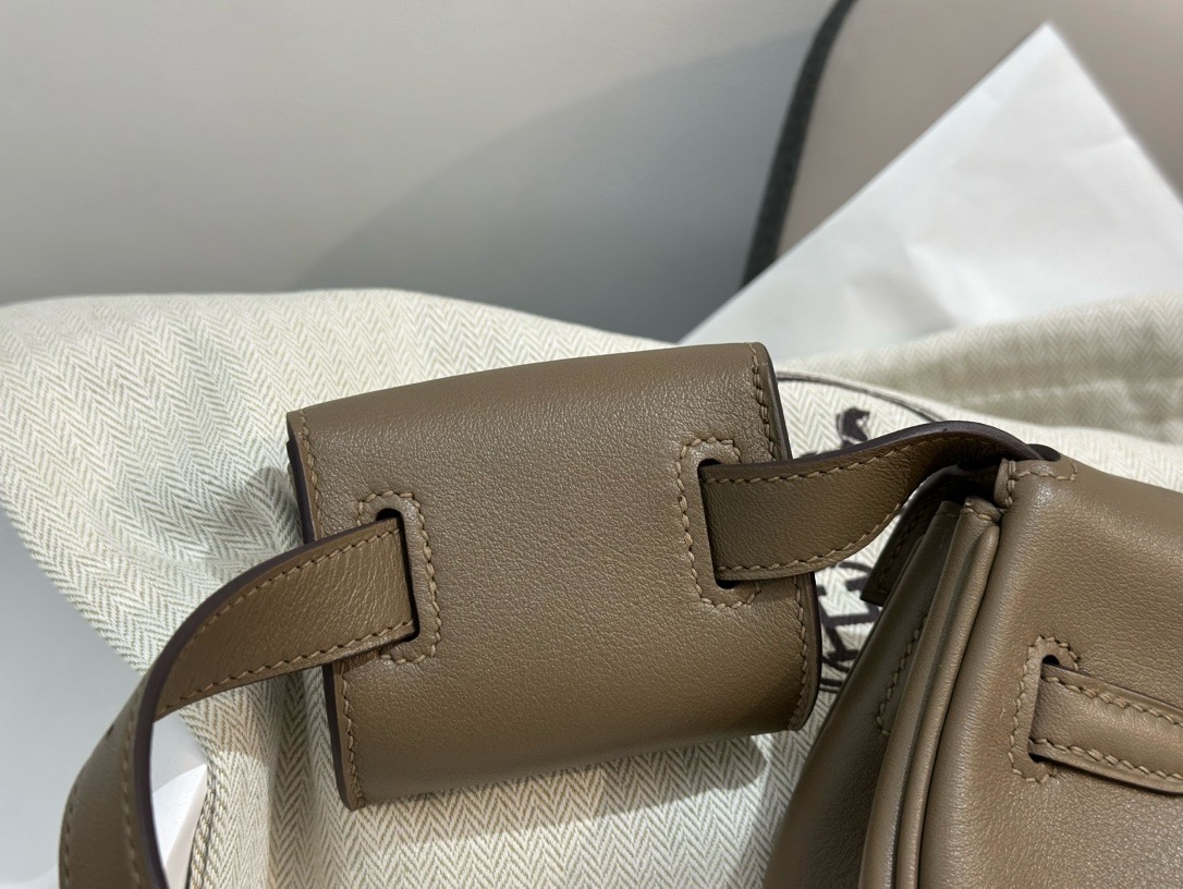 HERMÈS Swift Kelly Moove: Classic Elegance, Modern Flair. Discover the reimagined elegance of the Kelly Moove, where timeless style meets modern innovation. Building on the iconic silhouette of the beloved Kelly Banana bag, the Kelly Moove adds a fresh twist with an irresistibly chic detachable mini pouch on its strap. This miniature version of the Kelly is more than just a pretty accessory—it’s a practical companion perfect for holding essentials like AirPods or credit cards. Together, this mother-and-daughter duo brings both style and function to the forefront, making the Kelly Moove a must-have for those who appreciate classic design with a contemporary flair. Elevate your look with this sophisticated piece that seamlessly blends tradition with today’s needs.