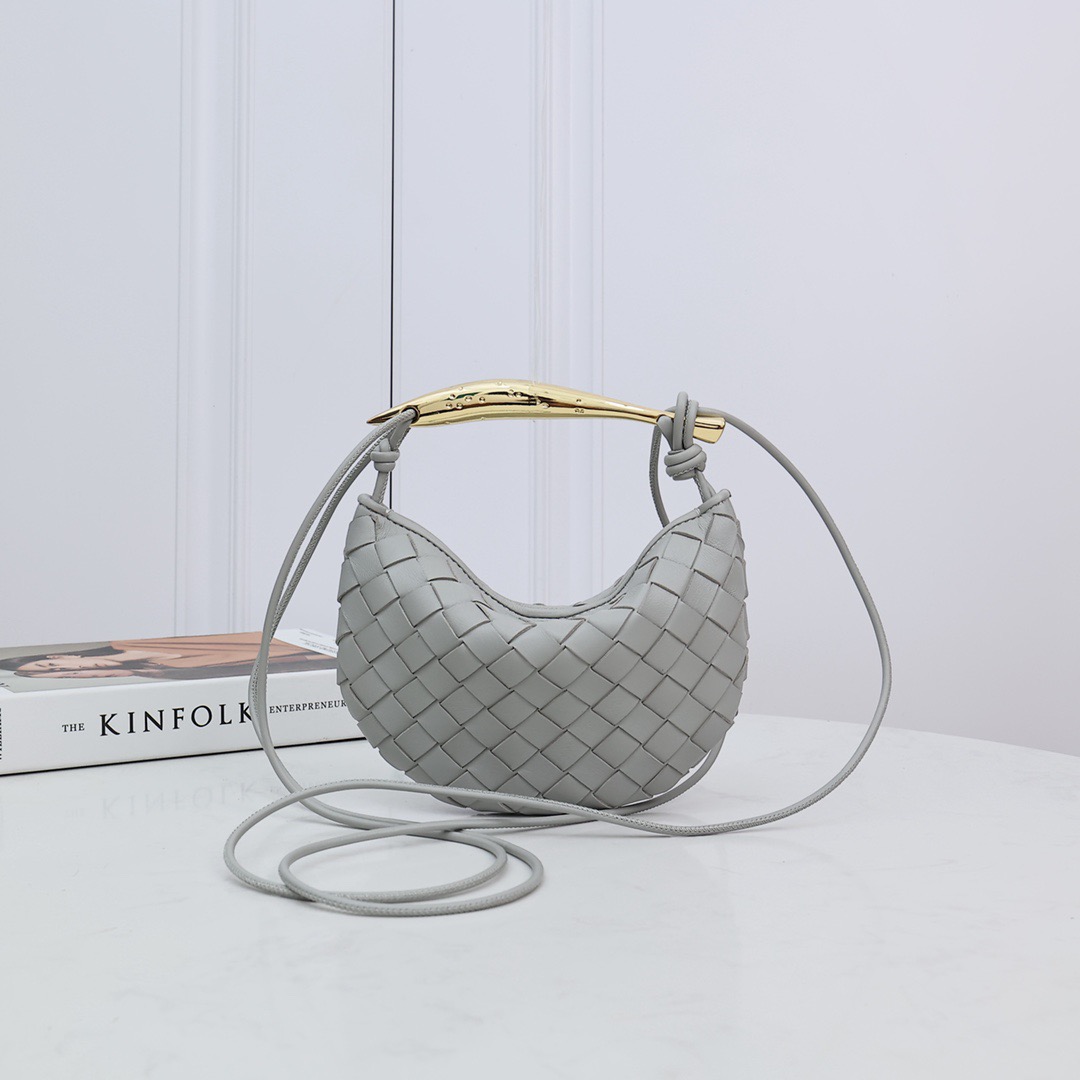 BOTTEGA VENETA Mini Sardine. Crafted to Perfection, Inspired by Nature: Your Timeless Companion for All Occasions. Bottega Veneta's masterful intrecciato weaving technique was originally crafted to ensure the enduring quality of leather goods. The Sardine Mini leather shoulder bag, meticulously fashioned from supple lamb leather, showcases a distinctive top handle reminiscent of a graceful fish. This versatile piece seamlessly transitions from day to night, making it the perfect, reliable companion to elegantly accommodate all your essentials.