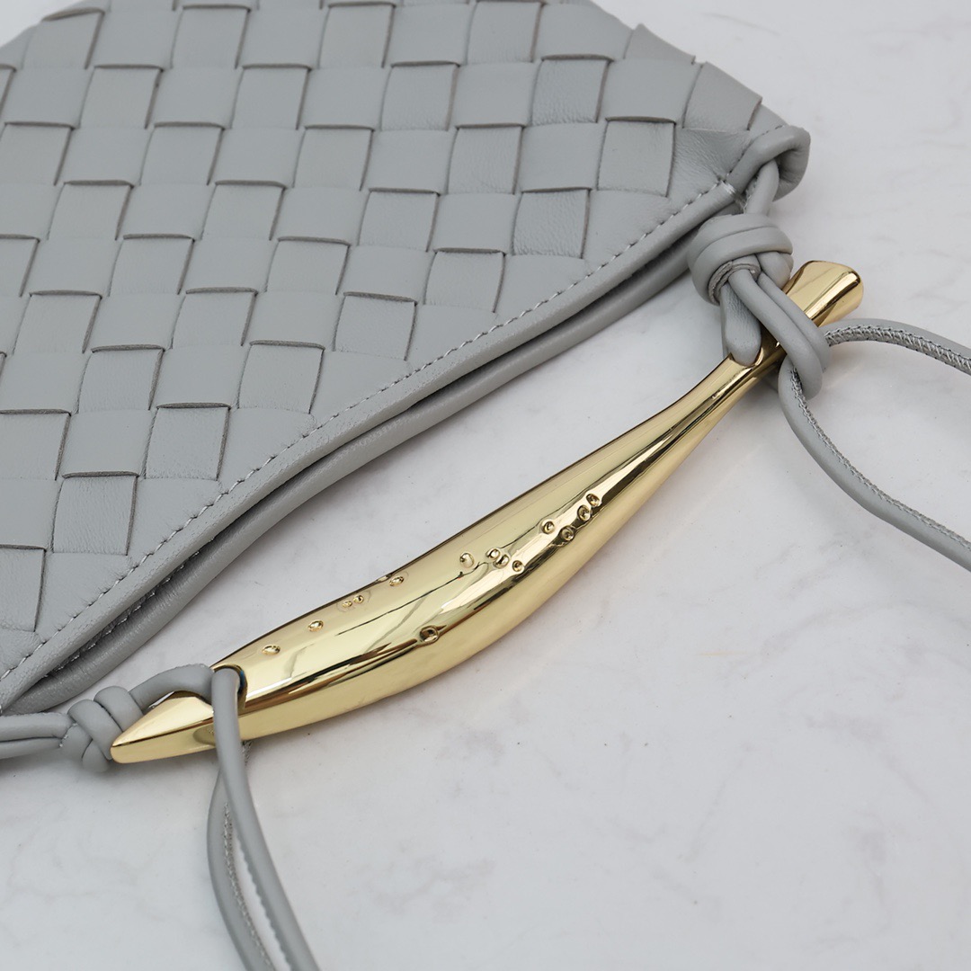 BOTTEGA VENETA Mini Sardine. Crafted to Perfection, Inspired by Nature: Your Timeless Companion for All Occasions. Bottega Veneta's masterful intrecciato weaving technique was originally crafted to ensure the enduring quality of leather goods. The Sardine Mini leather shoulder bag, meticulously fashioned from supple lamb leather, showcases a distinctive top handle reminiscent of a graceful fish. This versatile piece seamlessly transitions from day to night, making it the perfect, reliable companion to elegantly accommodate all your essentials.