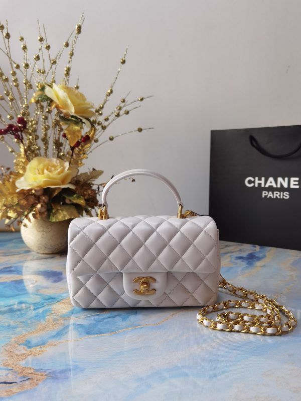 CHANEL 20 New Classic Mini Flap Bag With Handle. Original Quality Bag including gift box, care book, dust bag, authenticity card. This chic petite shoulder bag is crafted of luxurious shimmery lambskin leather. The crossbody bag features a long adjustable chain-link leather threaded shoulder strap and front flap with a CC turn lock. The flap opens to an interior of matching leather with zipper and patch pockets. Enjoy this fabulous bag for everyday essentials or special events.