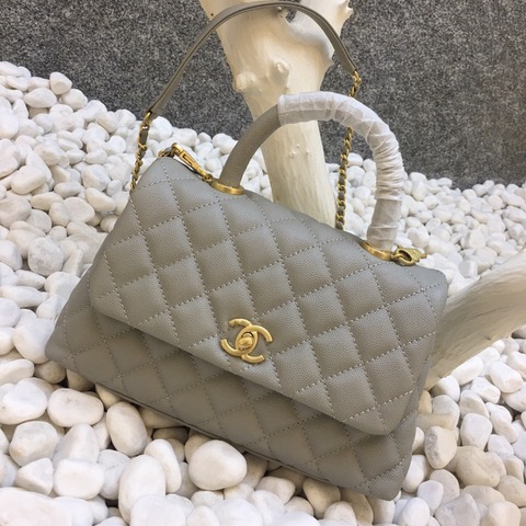 CHANEL Flap Bag with Coco Handle. Original Quality Bag including gift box, care book, dust bag, authenticity card. Despite the similarities to the Chanel Flap Bag, the Coco Handle stands apart from this and other popular Chanel models. And is perhaps the main reason behind it being unofficially renamed as the ‘Coco Handle’! The top ‘handle’ is its most distinctive feature. Structured and comfortably sized, it stands tall even when put down. The handle, combined with the trapezoid shape, bestows a modern touch to an otherwise classic style. Depending on the size you choose, the bag can find function as a day, an evening, or a day-to-night bag.