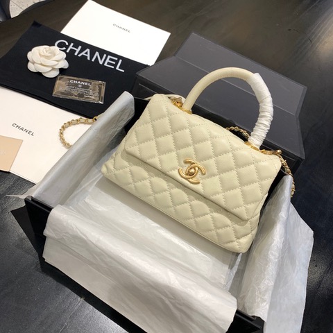CHANEL Flap Bag with Coco Handle. Original Quality Bag including gift box, care book, dust bag, authenticity card. Despite the similarities to the Chanel Flap Bag, the Coco Handle stands apart from this and other popular Chanel models. And is perhaps the main reason behind it being unofficially renamed as the ‘Coco Handle’! The top ‘handle’ is its most distinctive feature. Structured and comfortably sized, it stands tall even when put down. The handle, combined with the trapezoid shape, bestows a modern touch to an otherwise classic style. Depending on the size you choose, the bag can find function as a day, an evening, or a day-to-night bag.