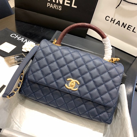 CHANEL Flap Bag with Coco Handle. Original Quality Bag including gift box, care book, dust bag, authenticity card. Despite the similarities to the Chanel Flap Bag, the Coco Handle stands apart from this and other popular Chanel models. And is perhaps the main reason behind it being unofficially renamed as the ‘Coco Handle’! The top ‘handle’ is its most distinctive feature. Structured and comfortably sized, it stands tall even when put down. The handle, combined with the trapezoid shape, bestows a modern touch to an otherwise classic style. Depending on the size you choose, the bag can find function as a day, an evening, or a day-to-night bag.