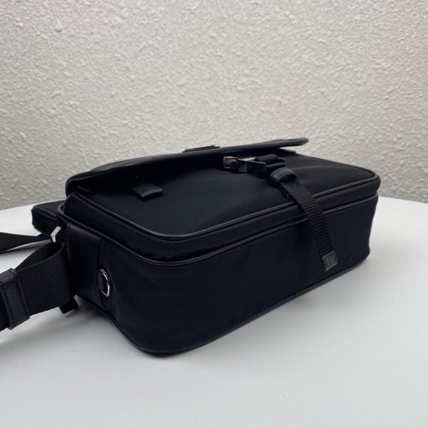 PRADA Nylon Cross-Body Bag. Original Quality Bag including gift box, care book, dust bag, authenticity card. This bag decorated with Saffiano leather trim presents compact volumes and a sleek design. With its distinctive side release buckle on the front, it comes with an easily adjustable shoulder strap. This cross-body bag featuring Saffiano leather trim with metal hardware and Prada logo lining, logo tag inside, enameled metal triangle logo outside. It has a main compartment with zipper, secondary compartment with flap and side release buckle, two front pockets, including one with zipper.