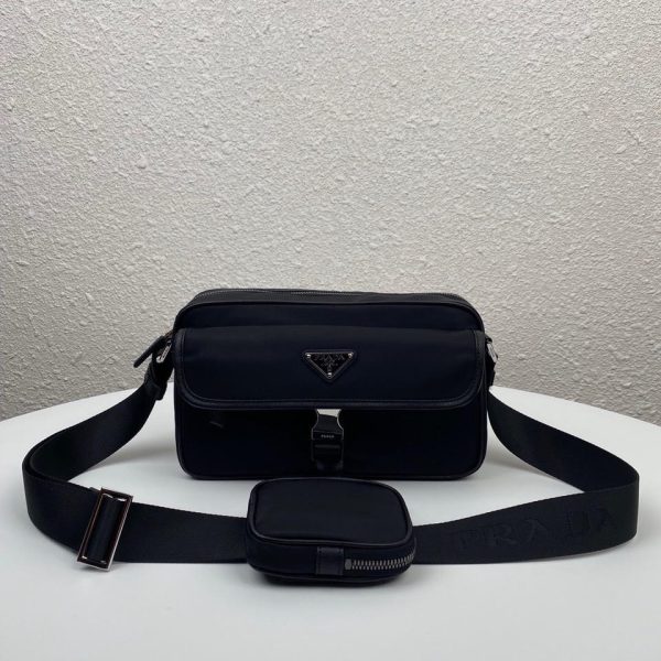 PRADA Nylon Cross-Body Bag. Original Quality Bag including gift box, care book, dust bag, authenticity card. This bag decorated with Saffiano leather trim presents compact volumes and a sleek design. With its distinctive side release buckle on the front, it comes with an easily adjustable shoulder strap. This cross-body bag featuring Saffiano leather trim with metal hardware and Prada logo lining, logo tag inside, enameled metal triangle logo outside. It has a main compartment with zipper, secondary compartment with flap and side release buckle, two front pockets, including one with zipper.