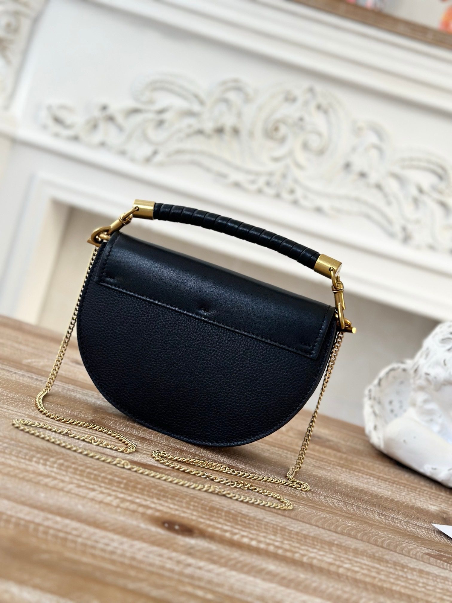 Marcie Chain Flap Bag. Authentic quality luxury bag crafted in genuine leather comes with authenticity card, dust bag and gift bag. Elevating Iconic Elegance: Marcie Line Redefined. Experience a fresh take on *loé's iconic Marcie line with this exquisite chain flap bag, meticulously crafted from a captivating blend of nappa lambskin, grained calfskin, and sumptuous suede. The line's signature hardware undergoes a graceful transformation, now adorned with *loé's engraved jewelry hallmark, adorning the flap with sophistication. An intricately hand-braided top handle pays homage to another hallmark Marcie feature, while a gracefully extended chain strap adds a refined touch. Whether you choose to drape it over your shoulder or wear it cross-body during the day, or opt to detach the strap and carry it by hand for a sophisticated evening ensemble, this flap bag is a versatile masterpiece. *loé's Marcie bag line effortlessly melds a feminine aesthetic with the free-spirited vibe of the '70s. An equestrian-inspired allure takes center stage, elevated by the allure of gleaming gold-toned hardware, resulting in a distinctly feminine yet timelessly chic look.