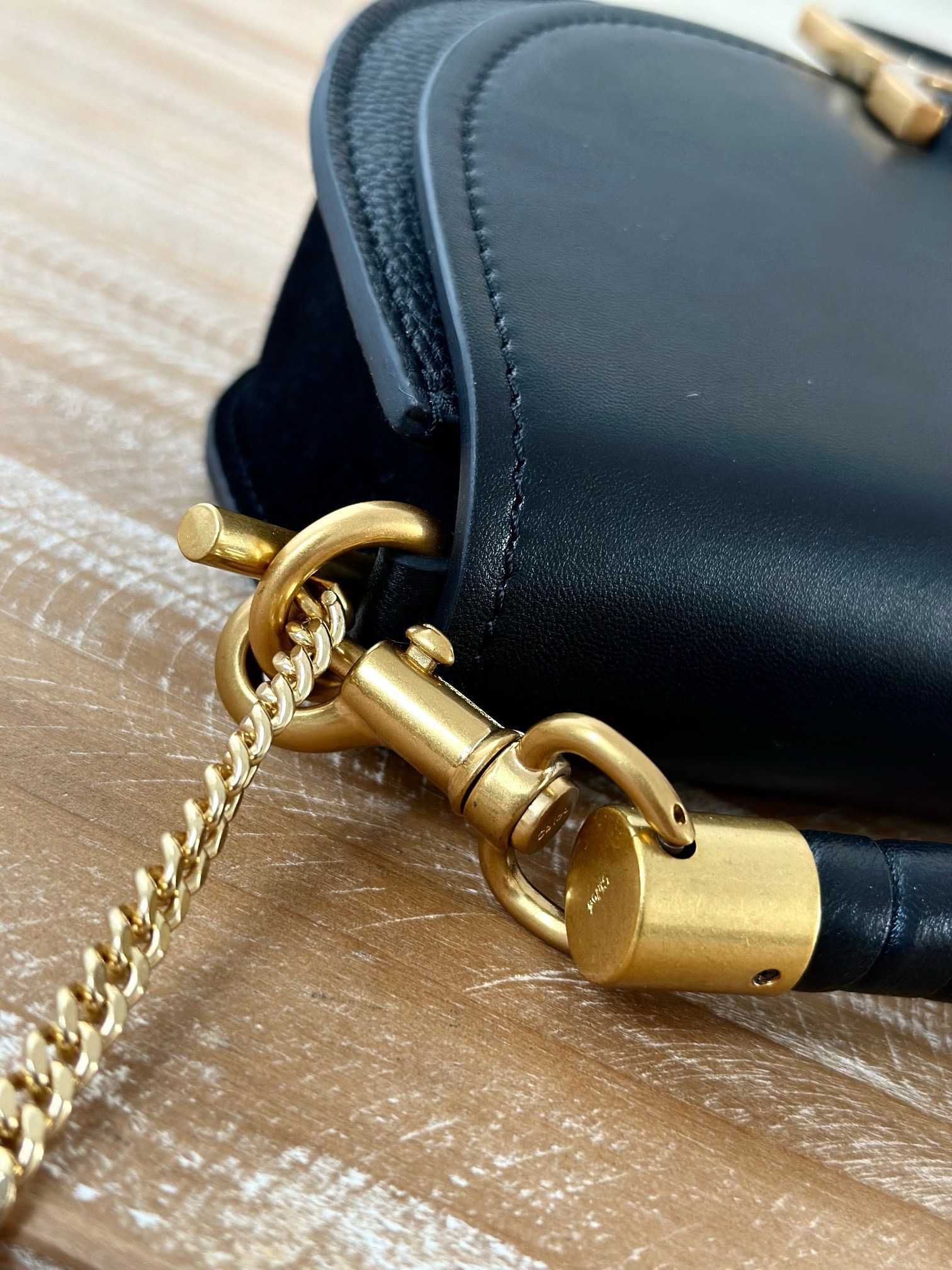 Marcie Chain Flap Bag. Authentic quality luxury bag crafted in genuine leather comes with authenticity card, dust bag and gift bag. Elevating Iconic Elegance: Marcie Line Redefined. Experience a fresh take on *loé's iconic Marcie line with this exquisite chain flap bag, meticulously crafted from a captivating blend of nappa lambskin, grained calfskin, and sumptuous suede. The line's signature hardware undergoes a graceful transformation, now adorned with *loé's engraved jewelry hallmark, adorning the flap with sophistication. An intricately hand-braided top handle pays homage to another hallmark Marcie feature, while a gracefully extended chain strap adds a refined touch. Whether you choose to drape it over your shoulder or wear it cross-body during the day, or opt to detach the strap and carry it by hand for a sophisticated evening ensemble, this flap bag is a versatile masterpiece. *loé's Marcie bag line effortlessly melds a feminine aesthetic with the free-spirited vibe of the '70s. An equestrian-inspired allure takes center stage, elevated by the allure of gleaming gold-toned hardware, resulting in a distinctly feminine yet timelessly chic look.