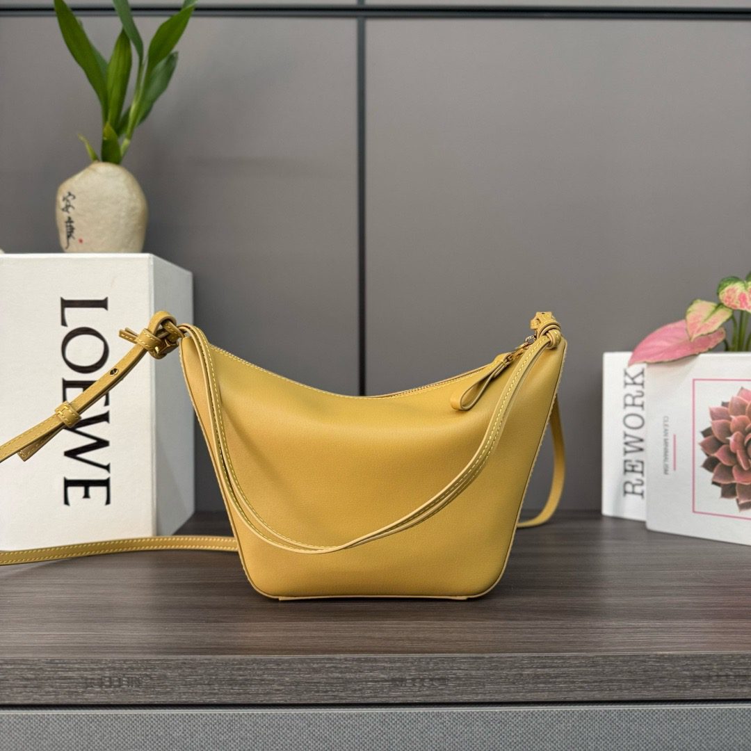 The Mini Hammock Hobo is a contemporary reimagining of *oewe’s iconic Hammock bag. This streamlined variation offers a sleek, sculptural silhouette designed as a versatile sling bag for modern living. Expertly crafted in classic calfskin, it features soft, supple leather and a compact form that adapts effortlessly to your day. The unique design allows for multiple carry options—wear it crossbody, over the shoulder, or by hand. Elegant yet functional, this mini hobo is perfect for essentials, making it an ideal choice for both daily wear and minimalist style statements.