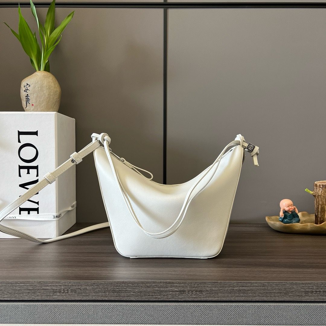 The Mini Hammock Hobo is a contemporary reimagining of *oewe’s iconic Hammock bag. This streamlined variation offers a sleek, sculptural silhouette designed as a versatile sling bag for modern living. Expertly crafted in classic calfskin, it features soft, supple leather and a compact form that adapts effortlessly to your day. The unique design allows for multiple carry options—wear it crossbody, over the shoulder, or by hand. Elegant yet functional, this mini hobo is perfect for essentials, making it an ideal choice for both daily wear and minimalist style statements.