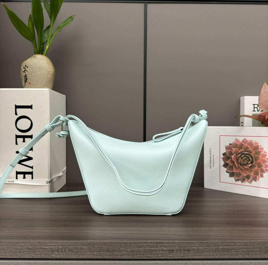 The Mini Hammock Hobo is a contemporary reimagining of *oewe’s iconic Hammock bag. This streamlined variation offers a sleek, sculptural silhouette designed as a versatile sling bag for modern living. Expertly crafted in classic calfskin, it features soft, supple leather and a compact form that adapts effortlessly to your day. The unique design allows for multiple carry options—wear it crossbody, over the shoulder, or by hand. Elegant yet functional, this mini hobo is perfect for essentials, making it an ideal choice for both daily wear and minimalist style statements.