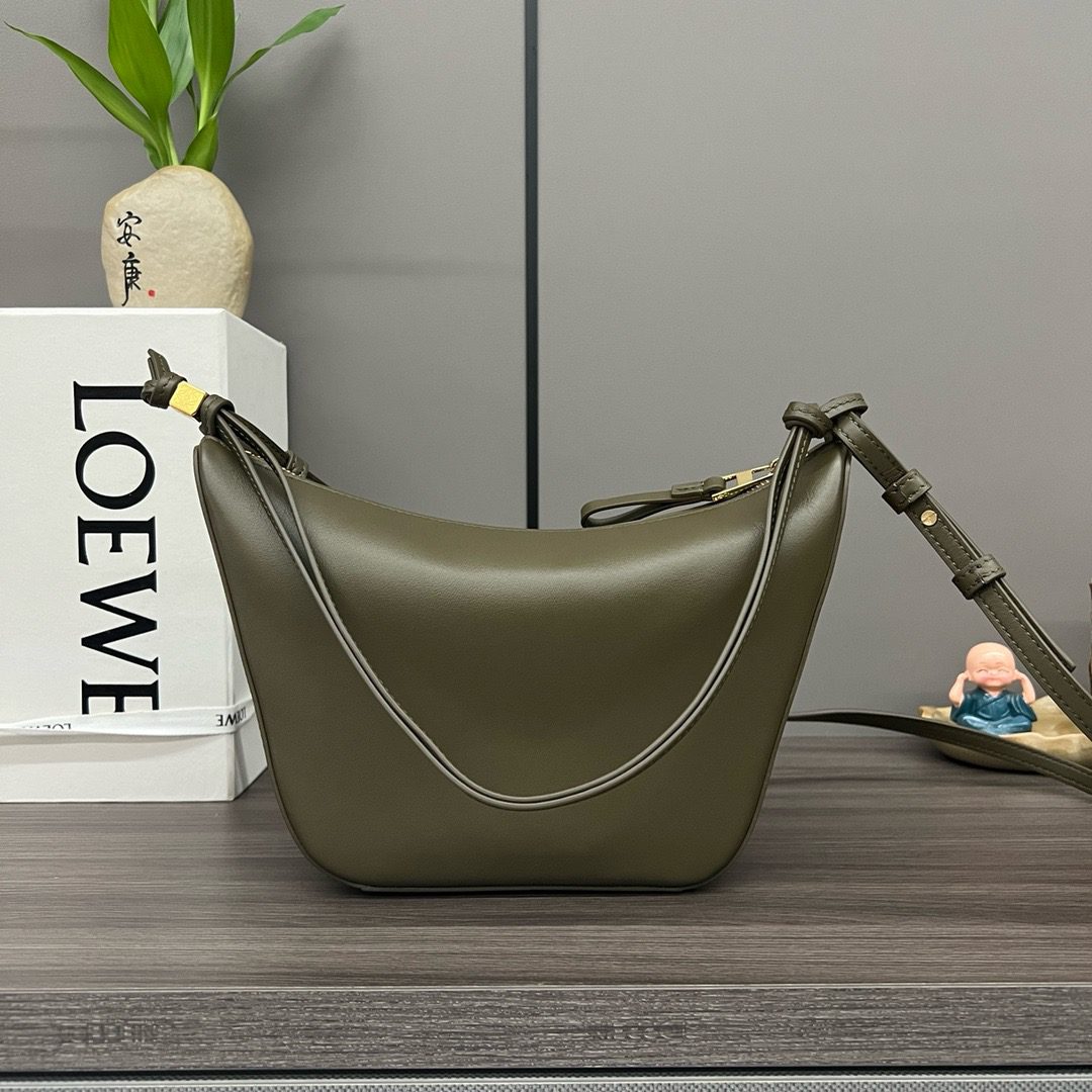 The Mini Hammock Hobo is a contemporary reimagining of *oewe’s iconic Hammock bag. This streamlined variation offers a sleek, sculptural silhouette designed as a versatile sling bag for modern living. Expertly crafted in classic calfskin, it features soft, supple leather and a compact form that adapts effortlessly to your day. The unique design allows for multiple carry options—wear it crossbody, over the shoulder, or by hand. Elegant yet functional, this mini hobo is perfect for essentials, making it an ideal choice for both daily wear and minimalist style statements.