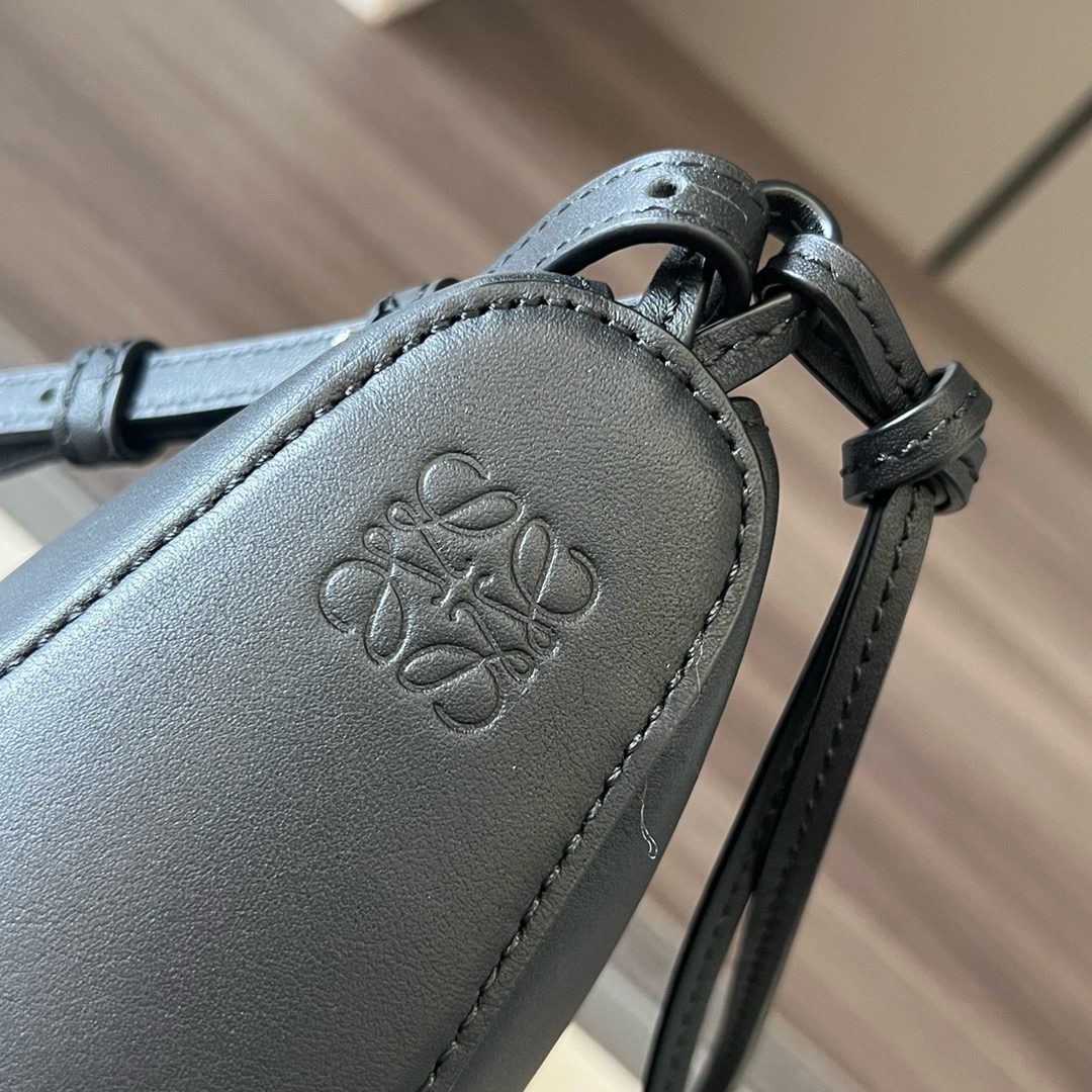 The Mini Hammock Hobo is a contemporary reimagining of *oewe’s iconic Hammock bag. This streamlined variation offers a sleek, sculptural silhouette designed as a versatile sling bag for modern living. Expertly crafted in classic calfskin, it features soft, supple leather and a compact form that adapts effortlessly to your day. The unique design allows for multiple carry options—wear it crossbody, over the shoulder, or by hand. Elegant yet functional, this mini hobo is perfect for essentials, making it an ideal choice for both daily wear and minimalist style statements.