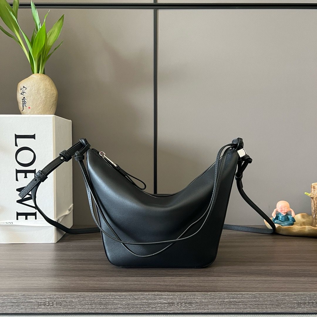 The Mini Hammock Hobo is a contemporary reimagining of *oewe’s iconic Hammock bag. This streamlined variation offers a sleek, sculptural silhouette designed as a versatile sling bag for modern living. Expertly crafted in classic calfskin, it features soft, supple leather and a compact form that adapts effortlessly to your day. The unique design allows for multiple carry options—wear it crossbody, over the shoulder, or by hand. Elegant yet functional, this mini hobo is perfect for essentials, making it an ideal choice for both daily wear and minimalist style statements.