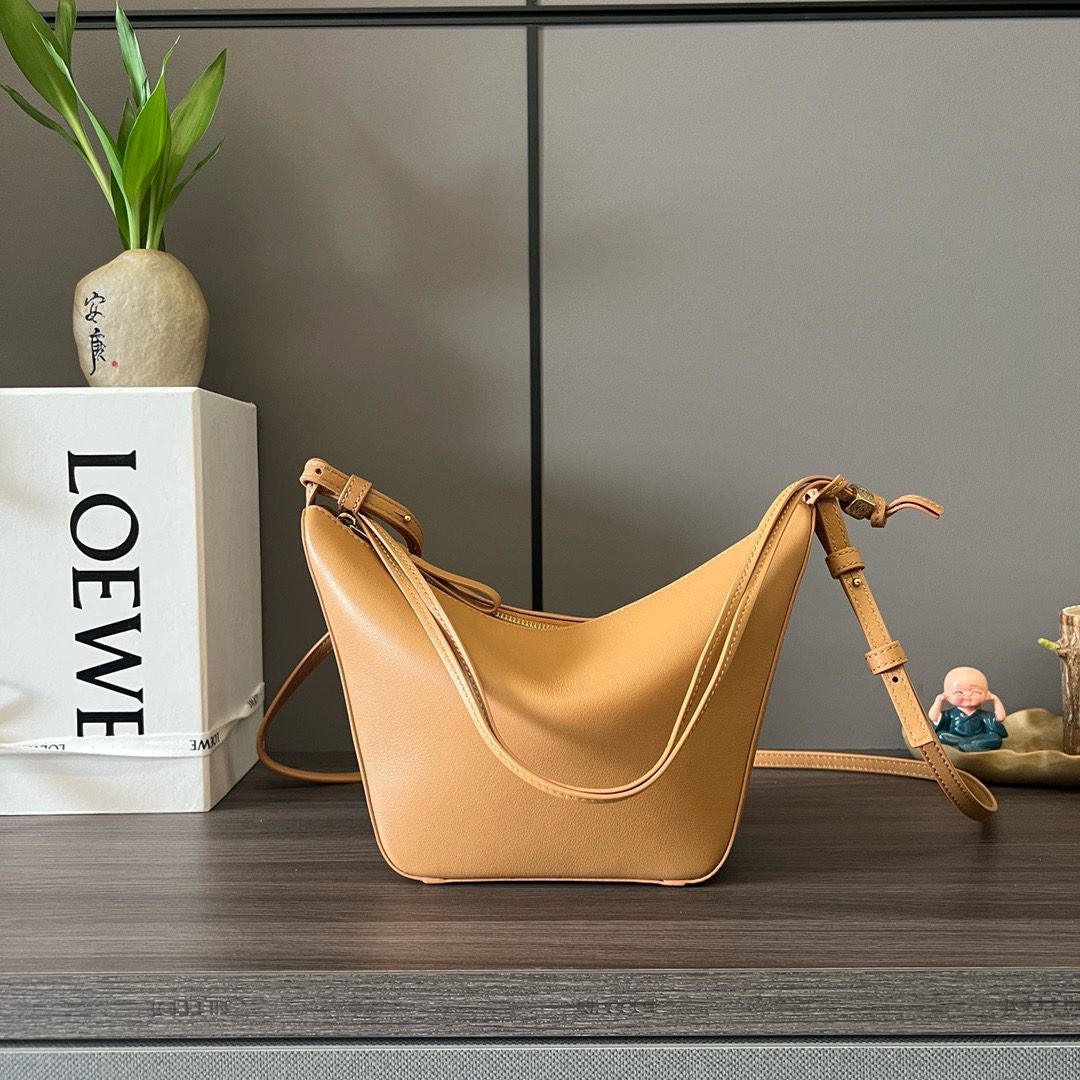 The Mini Hammock Hobo is a contemporary reimagining of *oewe’s iconic Hammock bag. This streamlined variation offers a sleek, sculptural silhouette designed as a versatile sling bag for modern living. Expertly crafted in classic calfskin, it features soft, supple leather and a compact form that adapts effortlessly to your day. The unique design allows for multiple carry options—wear it crossbody, over the shoulder, or by hand. Elegant yet functional, this mini hobo is perfect for essentials, making it an ideal choice for both daily wear and minimalist style statements.
