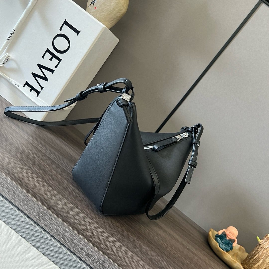The Mini Hammock Hobo is a contemporary reimagining of *oewe’s iconic Hammock bag. This streamlined variation offers a sleek, sculptural silhouette designed as a versatile sling bag for modern living. Expertly crafted in classic calfskin, it features soft, supple leather and a compact form that adapts effortlessly to your day. The unique design allows for multiple carry options—wear it crossbody, over the shoulder, or by hand. Elegant yet functional, this mini hobo is perfect for essentials, making it an ideal choice for both daily wear and minimalist style statements.