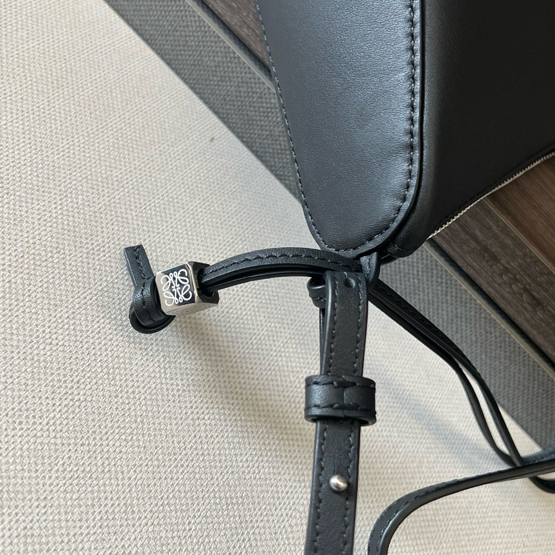 The Mini Hammock Hobo is a contemporary reimagining of *oewe’s iconic Hammock bag. This streamlined variation offers a sleek, sculptural silhouette designed as a versatile sling bag for modern living. Expertly crafted in classic calfskin, it features soft, supple leather and a compact form that adapts effortlessly to your day. The unique design allows for multiple carry options—wear it crossbody, over the shoulder, or by hand. Elegant yet functional, this mini hobo is perfect for essentials, making it an ideal choice for both daily wear and minimalist style statements.