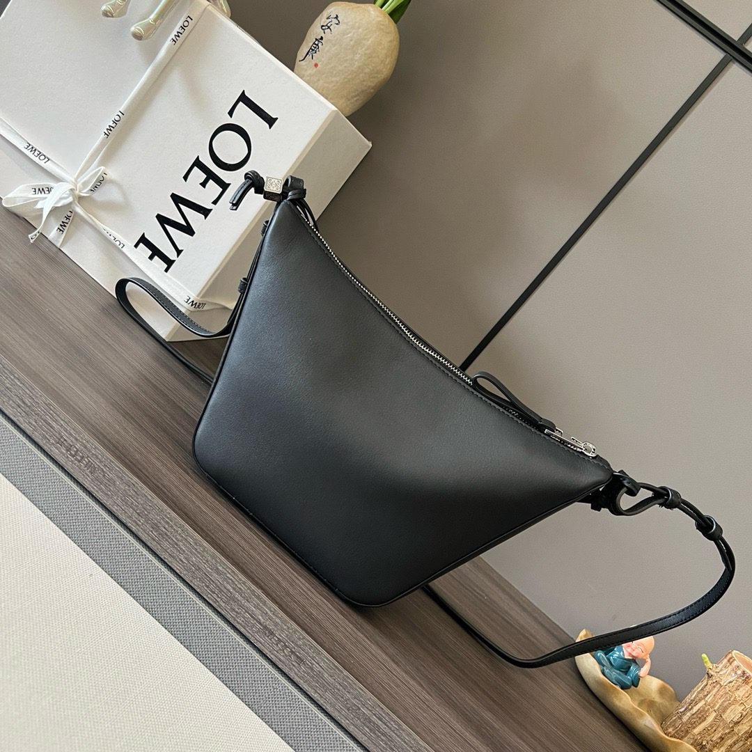 The Mini Hammock Hobo is a contemporary reimagining of *oewe’s iconic Hammock bag. This streamlined variation offers a sleek, sculptural silhouette designed as a versatile sling bag for modern living. Expertly crafted in classic calfskin, it features soft, supple leather and a compact form that adapts effortlessly to your day. The unique design allows for multiple carry options—wear it crossbody, over the shoulder, or by hand. Elegant yet functional, this mini hobo is perfect for essentials, making it an ideal choice for both daily wear and minimalist style statements.