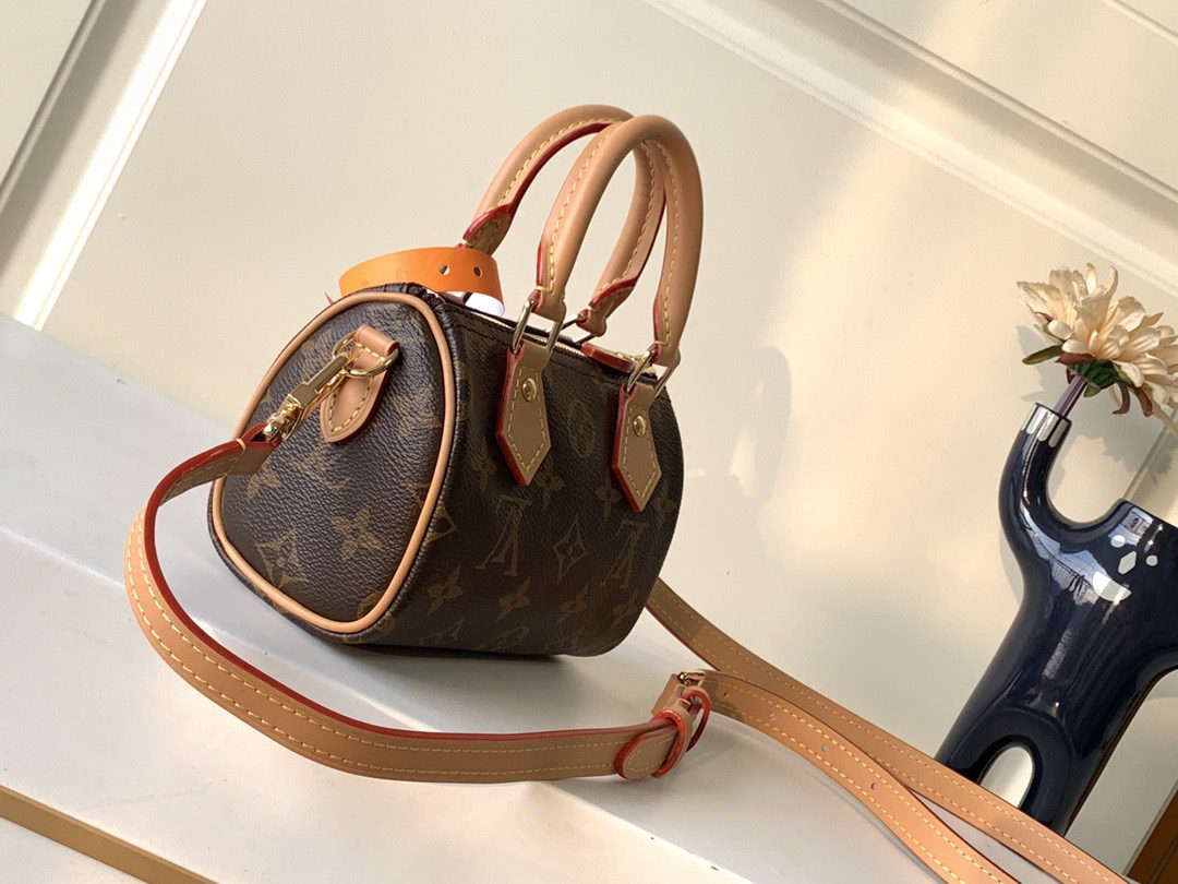 Speedy Nano. Authentic quality luxury bag crafted in genuine leather comes with authenticity card, dust bag and gift bag. Iconic Style, Perfectly Miniaturized. Meet the LV Speedy Nano — a petite powerhouse that captures the timeless allure of the iconic Speedy in its most charming form. Revamped in classic Monogram canvas and finished with aged natural cowhide leather, this mini marvel is made for the modern minimalist. Crafted with delicate gold-tone hardware and featuring two signature top handles, the Speedy Nano is both playful and practical. Its removable, adjustable shoulder strap adds effortless versatility—carry it by hand for polished poise or sling it crossbody for chic, on-the-go ease. Compact enough for your essentials. Iconic enough to turn heads. Small bag, big legacy!