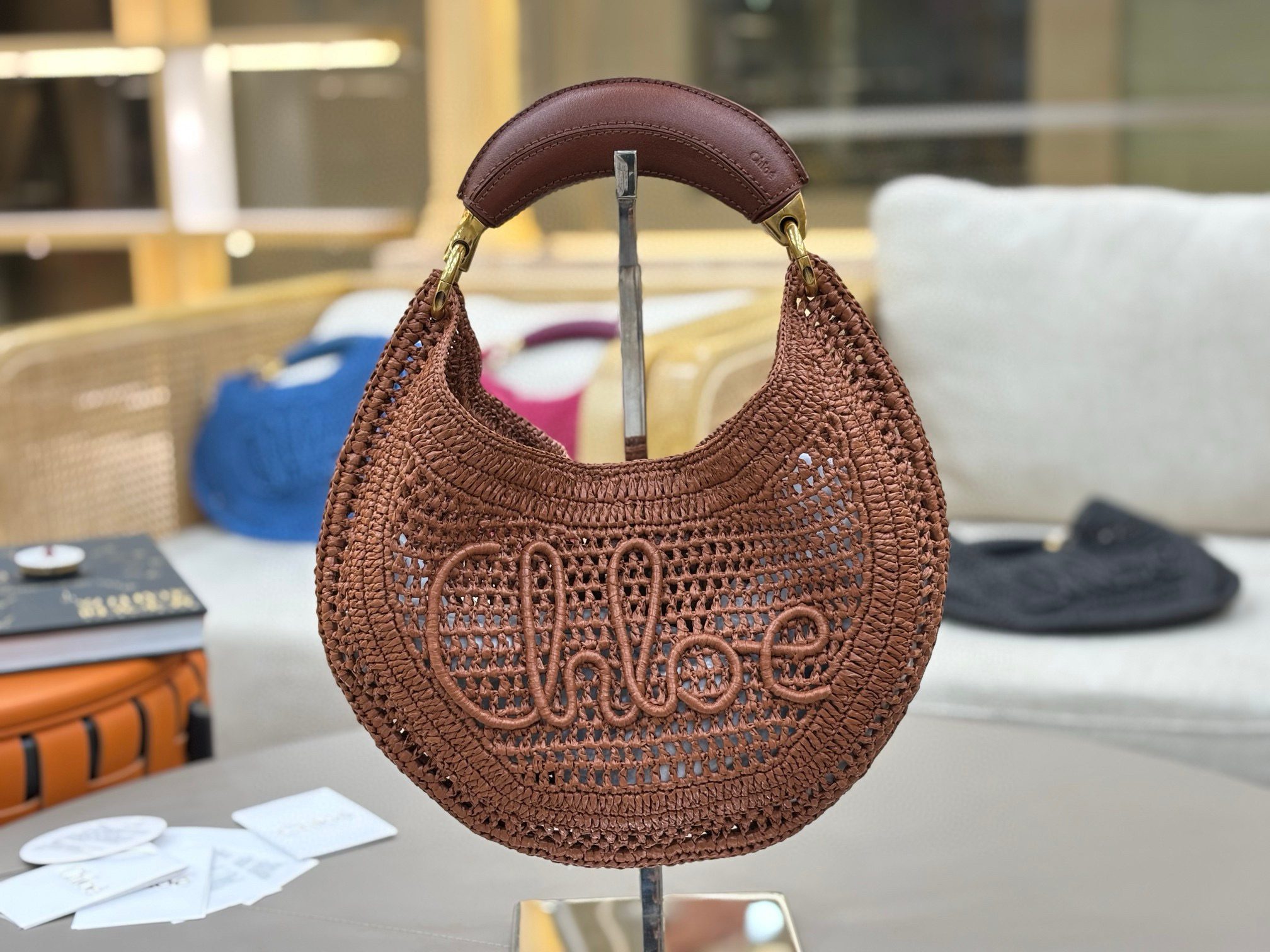 Summer Banana Hobo. Authentic quality luxury bag crafted in genuine leather comes with authenticity card, dust bag and gift bag. Artisanal Spirit, Curved in Style. Say hello to sunshine in bag form. The *LOÉ Summer Banana Hobo Bag is a joyful blend of craftsmanship and creativity, handwoven over four days by a single artisan in collaboration with Made For A Woman. This is not just a bag—it’s a story stitched in raffia and trimmed in luxurious calfskin. Its curved, banana-inspired silhouette hugs the shoulder with ease, while the sculptural handle and handwritten signature nod to *loé’s heritage of effortless elegance. Light, natural, and undeniably chic, it's the perfect companion for sun-soaked escapes or city strolls with a coastal state of mind. A celebration of craftsmanship, femininity, and the art of slow fashion.